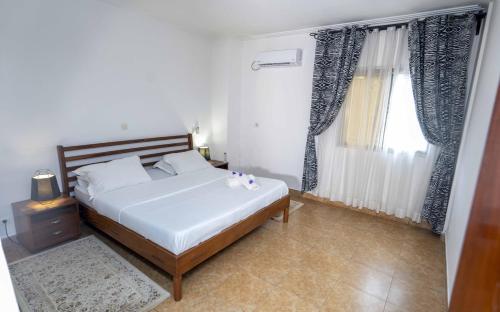 1 dormitorio con cama y ventana grande en GOLF VIEW RESIDENCE_STUDIO, en Yaoundé