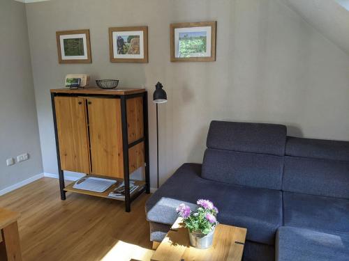 a living room with a blue couch and a table at Schmugglernest in Monschau
