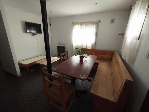 Habitación con mesa, sillas y ventana en Casa de Montaña en San Carlos de Bariloche