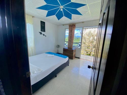 1 dormitorio con 1 cama con una estrella azul en el techo en La Morena Hospedaje, en Acacías
