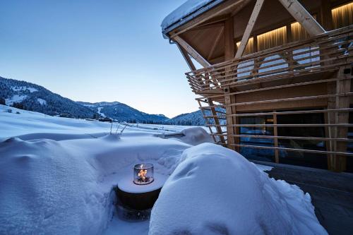 a house covered in snow next to a snow covered yard at HUBERTUS Mountain Refugio Allgäu in Balderschwang