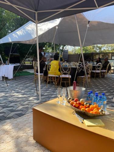 a table with a bowl of tomatoes and bottles of water at SapzRes at Klerksdorp in Klerksdorp