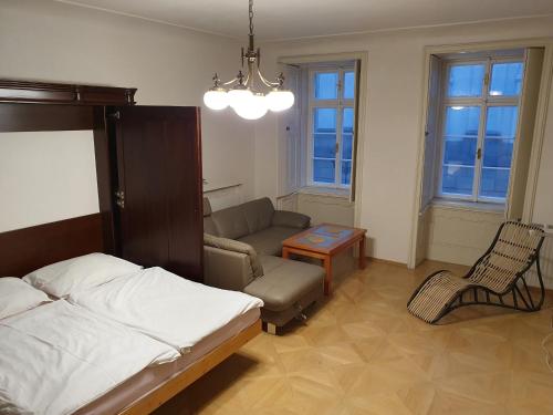 プラハにあるOld Town Apartmentのベッドルーム1室(ベッド1台、ソファ、テーブル付)