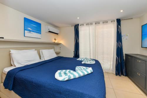 a bedroom with a blue bed with towels on it at Boutique Hotel Swiss Paradise Aruba Villas and Suites in Palm-Eagle Beach