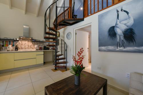 a living room with a staircase and a table at Boutique Hotel Swiss Paradise Aruba Villas and Suites in Palm-Eagle Beach