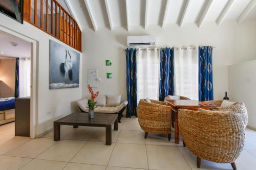 a living room with a table and chairs at Boutique Hotel Swiss Paradise Aruba Villas and Suites in Palm-Eagle Beach