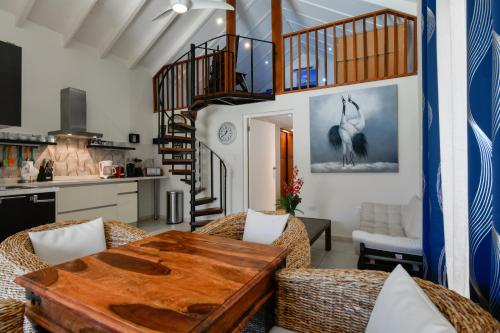 a living room with a table and a spiral staircase at Boutique Hotel Swiss Paradise Aruba Villas and Suites in Palm-Eagle Beach