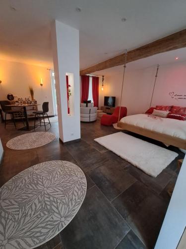 a bedroom with a large bed and a living room at Ba'Cam SPA in Étigny