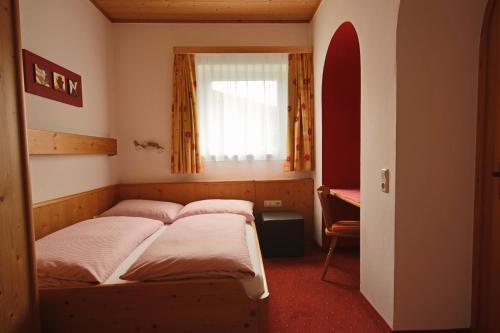 a bedroom with a bed and a window in it at Pension Riedlsperger in Saalbach Hinterglemm