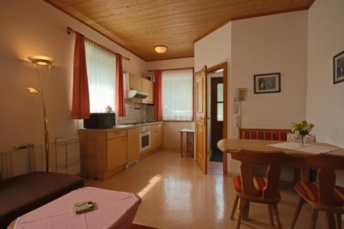a kitchen and a living room with a table and a dining room at Pension Riedlsperger in Saalbach Hinterglemm