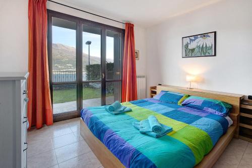 a bedroom with a bed and a large window at Ampia vista sul lago di Como in Bellano