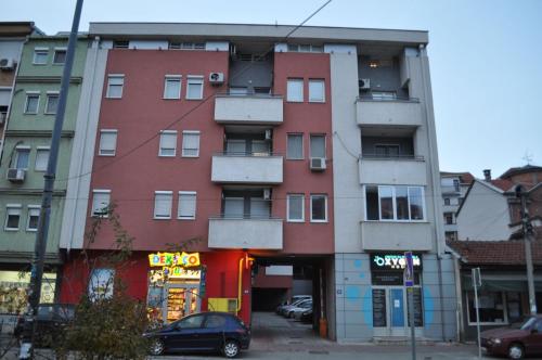a tall building with cars parked in front of it at Apartman Zvezdica -Smederevo, Netflix in Smederevo