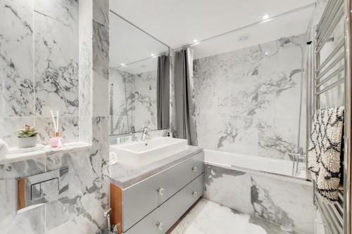 a white bathroom with a sink and a tub at The Princes Boutique in London