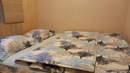 a bed with blue and white blankets on it at Apartment ANI in Vagharshapat
