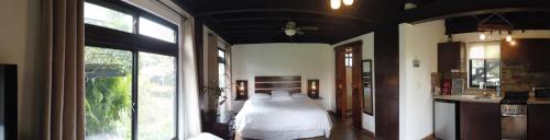 a bedroom with a bed in a room with windows at El Granero De Frida in Boquete