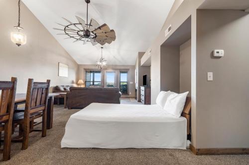 a bedroom with a large white bed and a living room at Table Rock Resorts at Indian Point in Branson