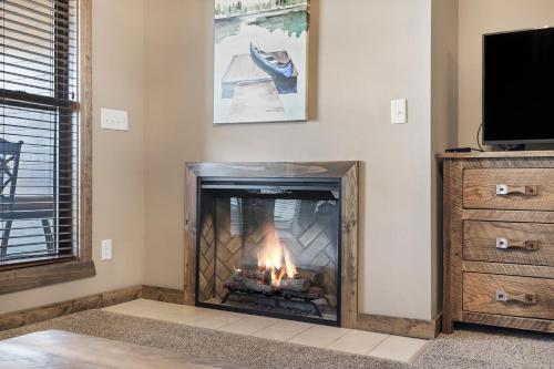 a fireplace in a living room with a fire at Table Rock Resorts at Indian Point in Branson