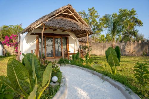 a small house with a thatched roof at Aya Beach Resort in Kizimkazi