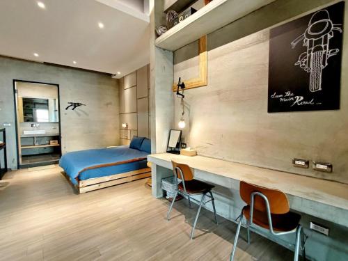 a bedroom with a bed and a desk and chairs at 墾丁恆春包棟 l 洛夫特Looft民宿 in Hengchun South Gate