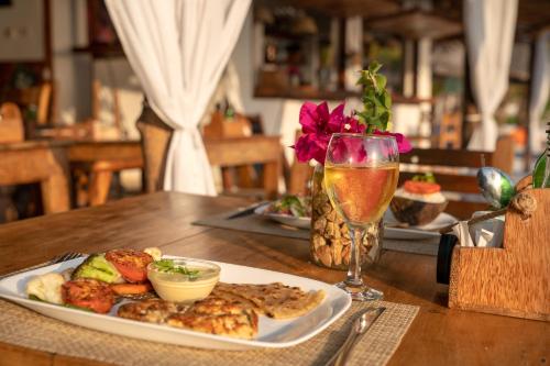 a plate of food and a glass of wine on a table at Aya Beach Resort in Kizimkazi
