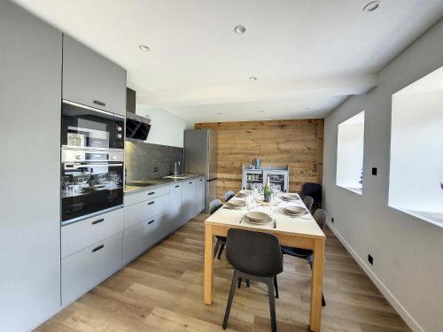 une cuisine avec une table et des chaises dans une pièce dans l'établissement GREEN MARMOTTES 1 - Saint Jean D Aulps pied des pistes, à Saint-Jean-dʼAulps