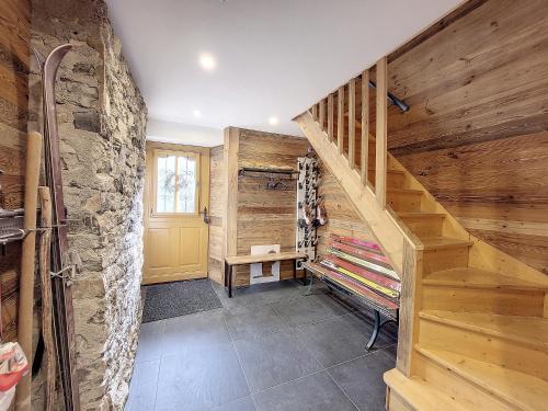 - un escalier en bois dans une chambre dotée d'un mur en pierre dans l'établissement GREEN MARMOTTES 1 - Saint Jean D Aulps pied des pistes, à Saint-Jean-dʼAulps