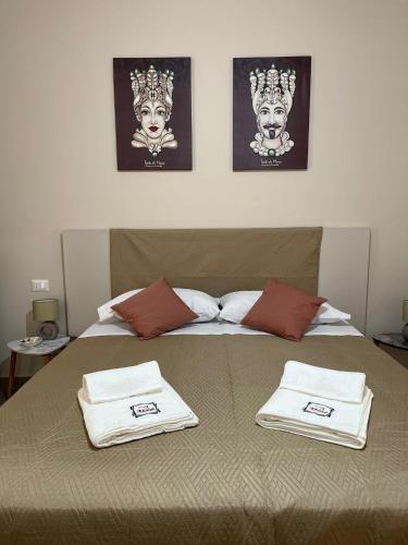 a bed with two towels on top of it at A boné Guest house in Catania