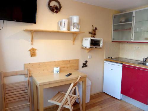 une petite cuisine avec une table et un micro-ondes dans l'établissement Studio au cœur de Tignes Le Lac · Proche pistes et commodités · Animaux acceptés - FR-1-502-461, à Tignes