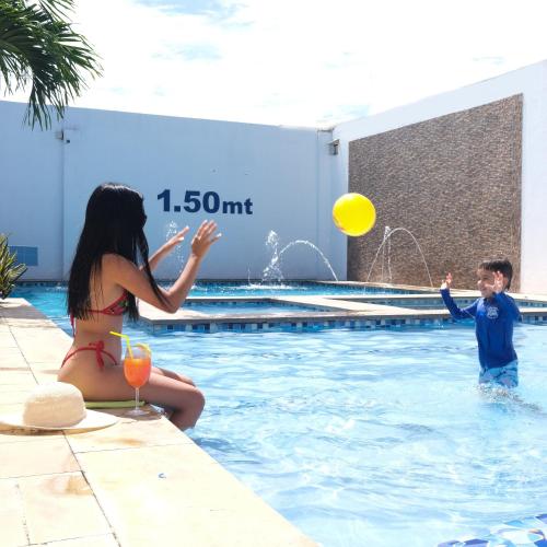 a boy and a girl playing in a swimming pool at Hotel Bella Isa in La Dorada