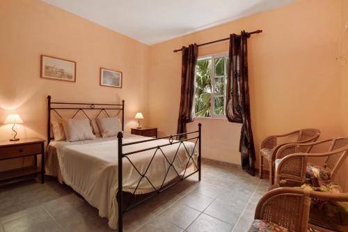 1 dormitorio con cama, ventana y silla en Casa Catarina, en Junqueira
