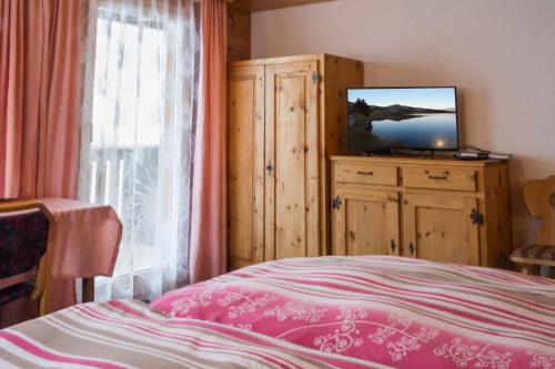ベットマーアルプにあるChalet Weisshorn 3のベッドルーム(ベッド1台、ドレッサー内のテレビ付)