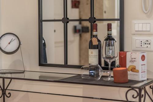 una mesa con dos botellas de vino y un reloj en Italian Experience-Rio San Lorenzo Boutique Apartment, en Venecia