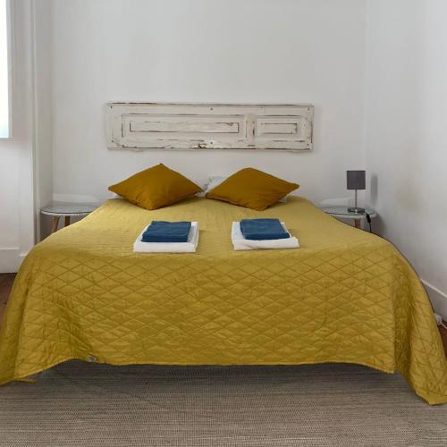 a bedroom with a yellow bed with two towels on it at 1924 in Lisbon
