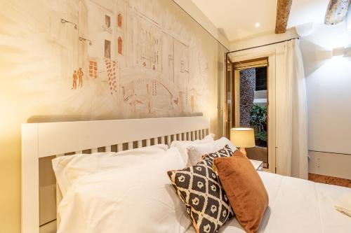 1 dormitorio con cama blanca y almohadas blancas en Italian Experience-Rio San Lorenzo Boutique Apartment, en Venecia