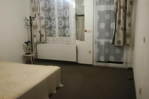 1 dormitorio con 1 cama y una ventana con cortinas en Apartmán Krkonoše - dvoulůžkový pokoj s koupelnou, en Vrchlabí