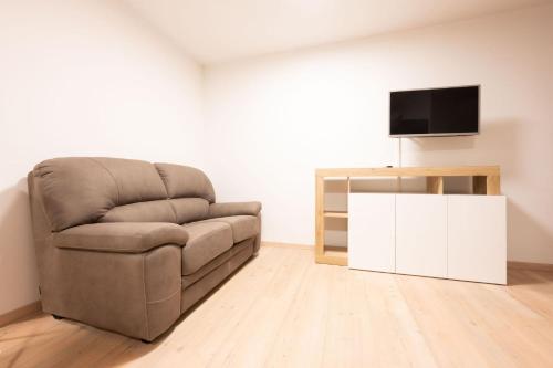 a living room with a couch and a tv at Cesa Meida 2A in Pozza di Fassa