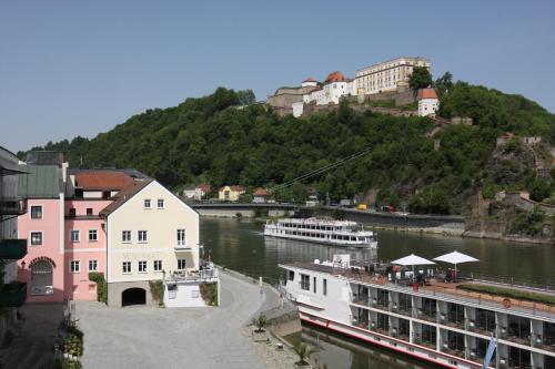 a view of a river with buildings and a boat at Altstadt-Hotel Passau in Passau
