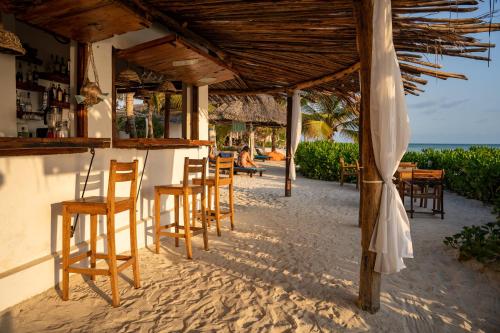 a bar with chairs and tables on the beach at Aya Beach Resort in Kizimkazi