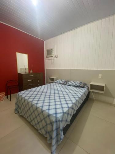 1 dormitorio con cama y pared roja en Casa do Sussego, en Foz do Iguaçu