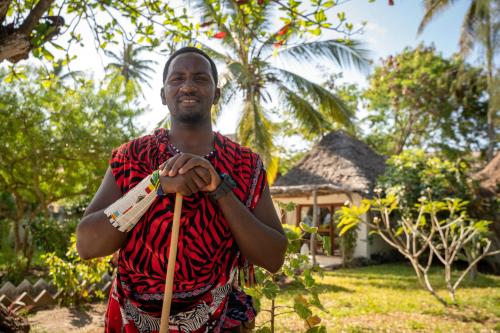 a man holding a rope in front of a house at Aya Beach Resort in Kizimkazi