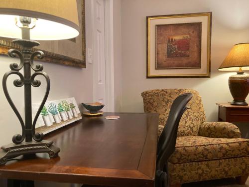 a table with a lamp and a chair in a room at Spacious 3 Bedroom 2 bath Condo close to Five-points in Athens in Athens