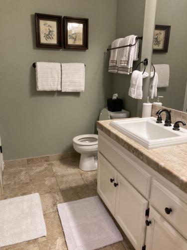 a bathroom with a sink and a toilet and towels at Spacious 3 Bedroom 2 bath Condo close to Five-points in Athens in Athens