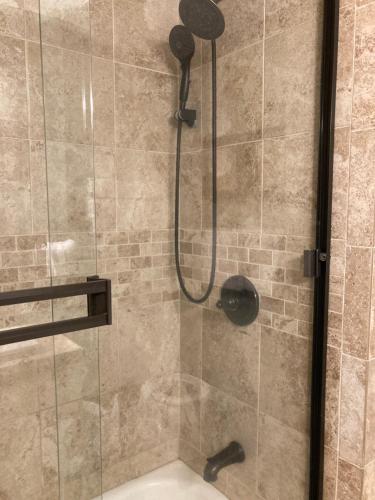 uma casa de banho com um chuveiro e uma porta de vidro em Spacious 3 Bedroom 2 bath Condo close to Five-points in Athens em Athens