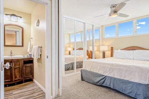 a bedroom with a bed and a sink and a mirror at Hale Ono Loa Condo in Kahana