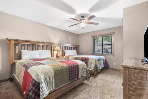 a bedroom with two beds and a ceiling fan at Table Rock Resorts at Indian Point in Branson