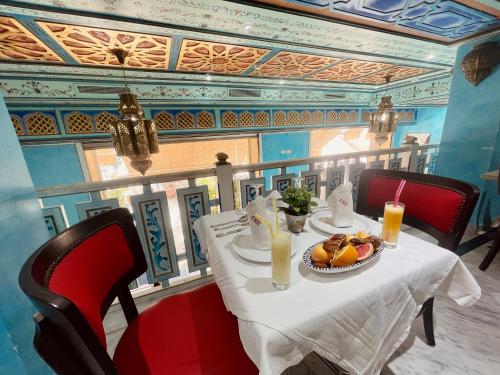 a table with a plate of fruit and drinks on it at Royal Victoria - Ex British Embassy in Tunis