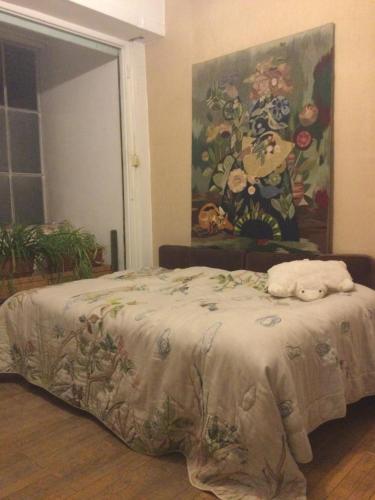 un lit dans une chambre avec un tableau sur le mur dans l'établissement Evelyns private nostalgic rooms, à Strasbourg