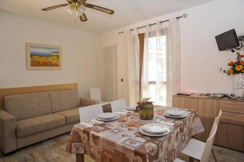 sala de estar con mesa y sofá en La Casa dei Nonni sul Garda, en Peschiera del Garda