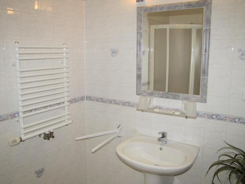 a white bathroom with a sink and a mirror at Penzion Aldo in Karviná
