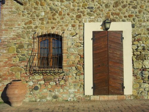 a brick building with a door and a window at Agriturismo Ragoncino in Laiatico